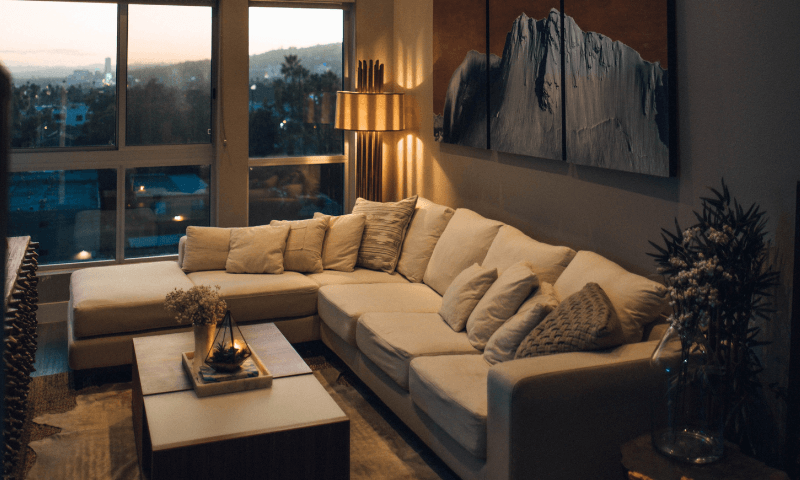 salon avec un &eacute;clairage chaleureux et une fen&ecirc;tre donnant sur le coucher de soleil