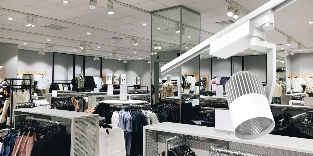 Clothing store with LED ceiling panel lighting, featuring a square LED panel.