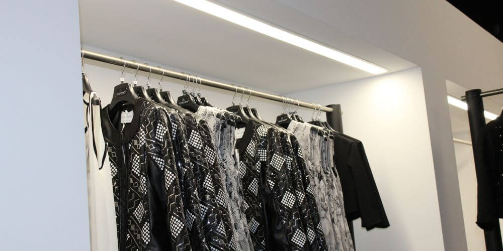 AREM LED linear fixture installed on top of a clothing display